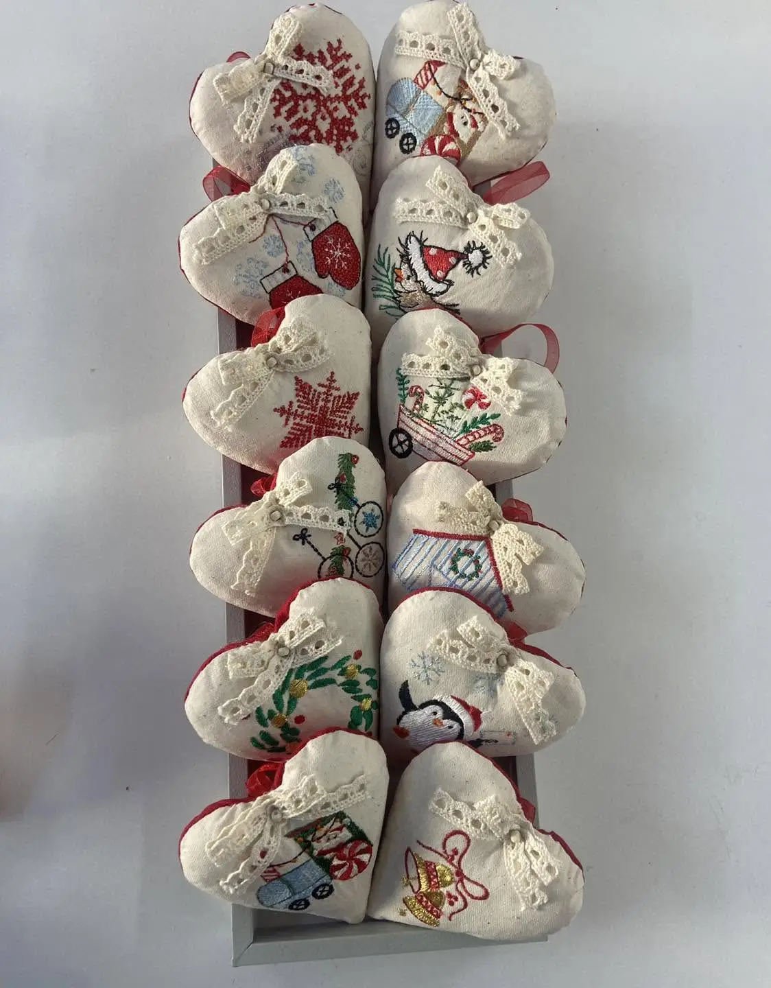 Tavă cu inimioare textile de Crăciun, fiecare brodată cu alt desen de iarnă