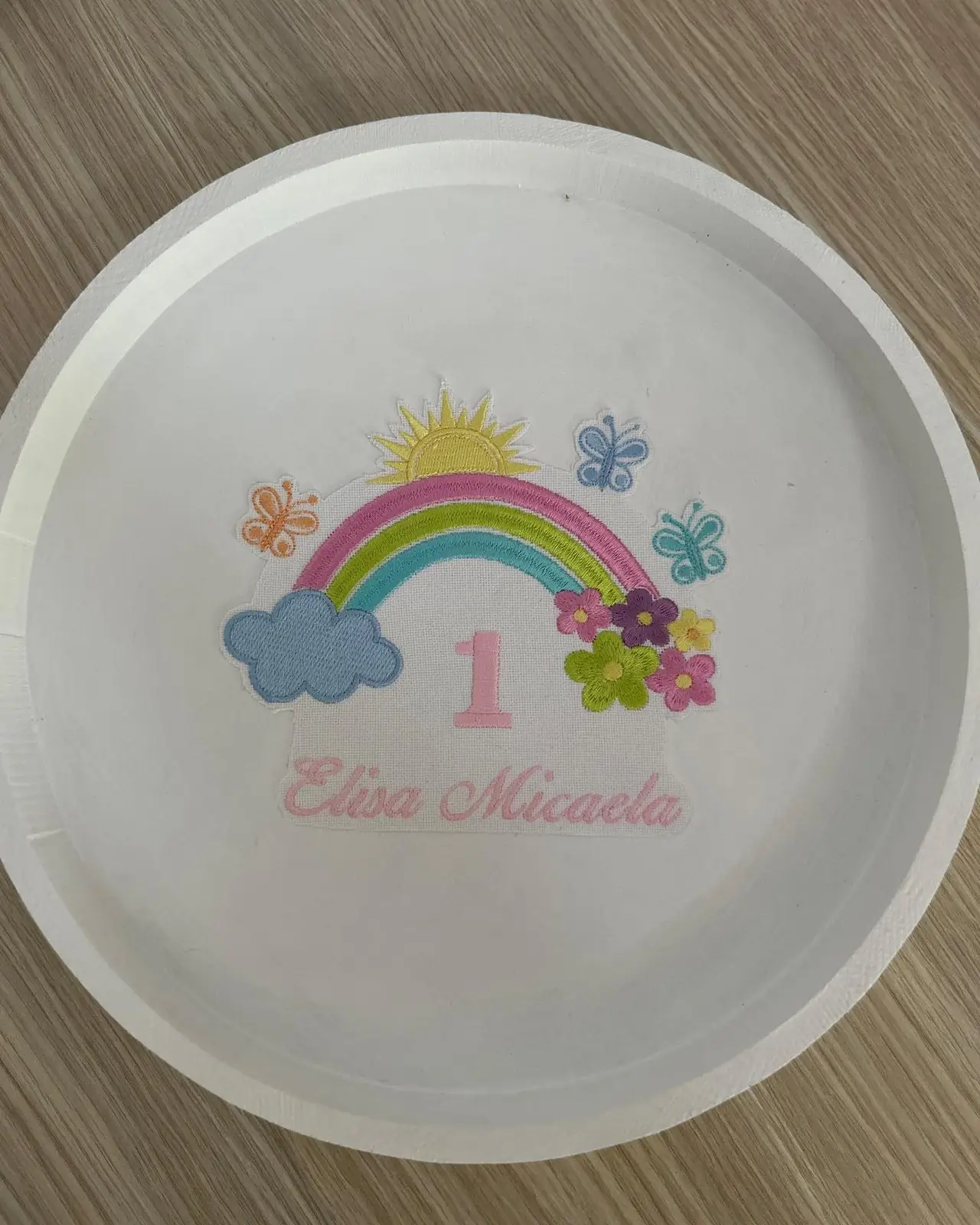 Tăviță rotundă albă pentru moț, brodată cu curcubeu, cifra 1 și numele fetiței